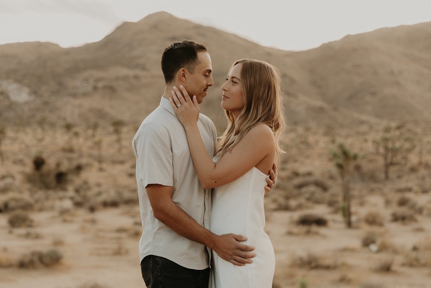 A couple embrace during their Joshua Tree engagement shoot.