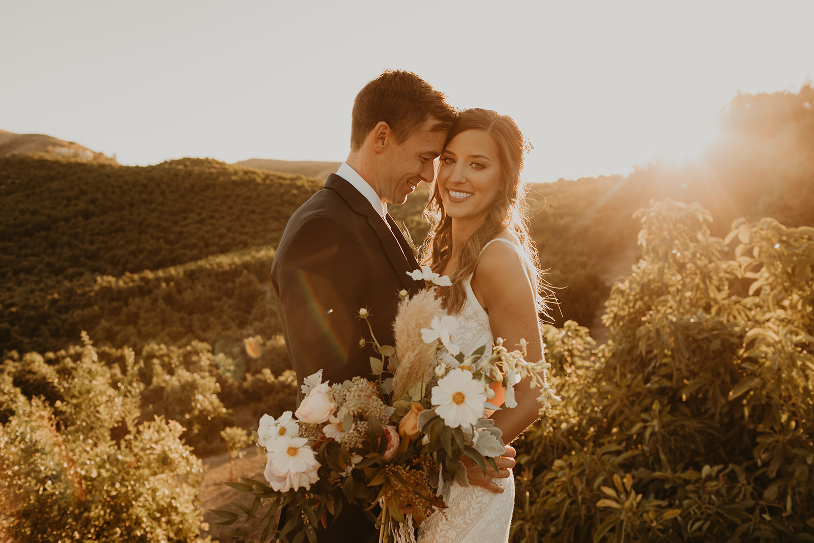 Bride and groom embrace and pose during sunset of their California Destination Wedding by Maya Lora